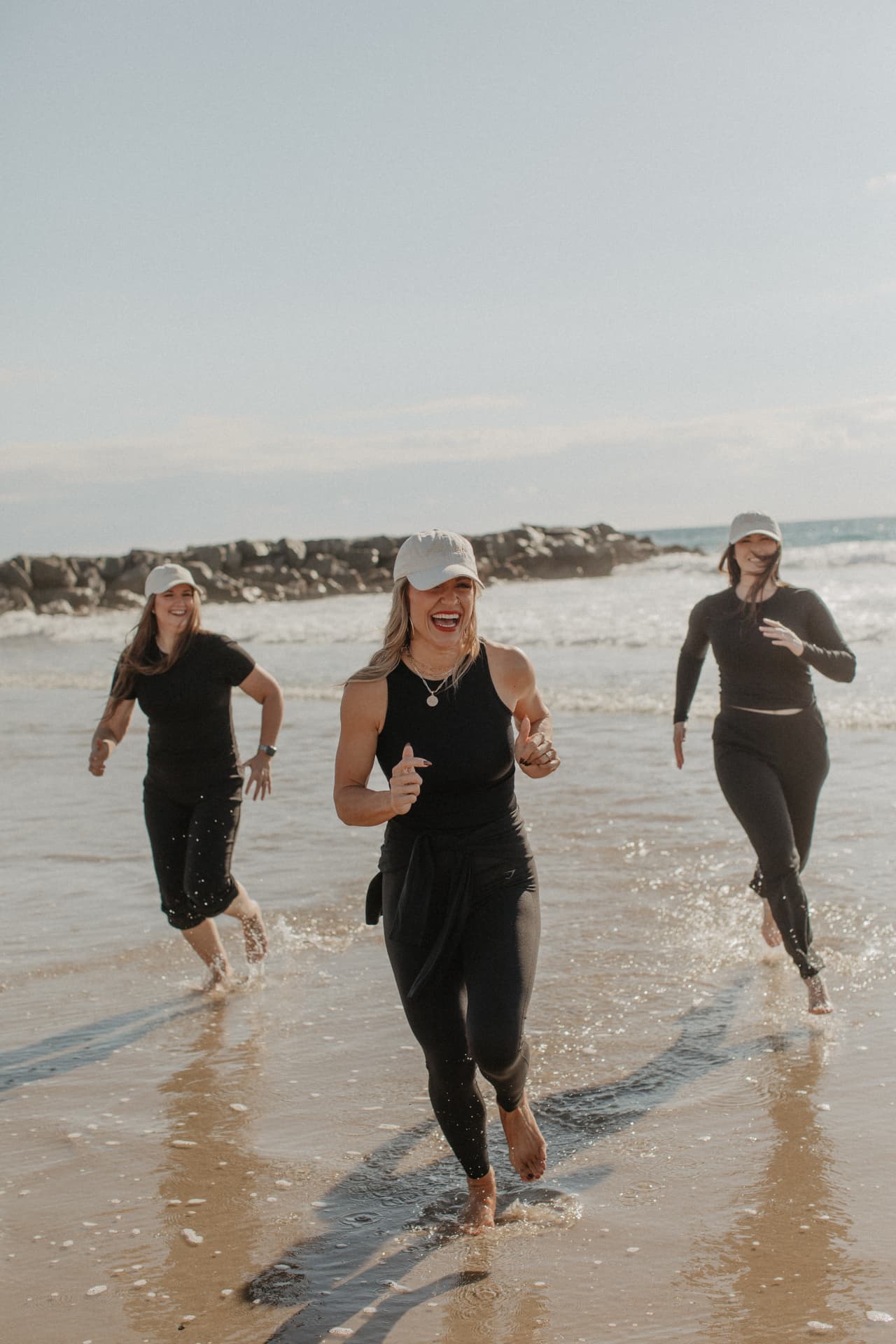 Inner Circle members laughing together in the ocean at the 2026 Newport Beach retreat